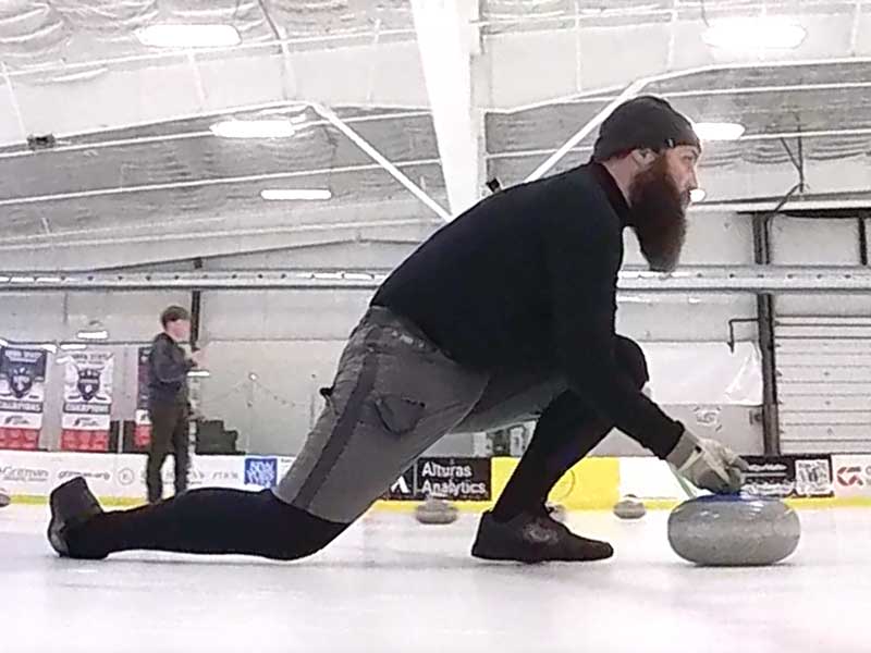 Curler launching a stone at Palouse Ice Rink